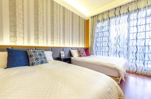 a bedroom with two beds and a window at Relax BnB in Dongshan