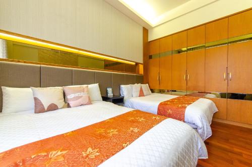 冬山鄉的住宿－自然醒精品民宿，酒店客房设有两张床和木制橱柜。