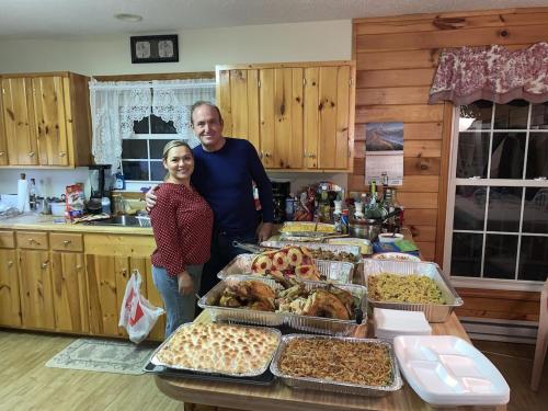 a man and woman standing in front of a table of food at CAPE CODE BEAUTY IN THE APPALACHIANS in Piney Creek