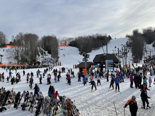 a large group of people skiing on a snow covered slope at CAPE CODE BEAUTY IN THE APPALACHIANS in Piney Creek