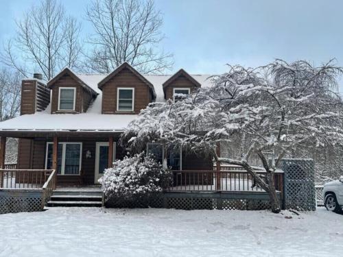 a house covered in snow with a car parked in front at CAPE CODE BEAUTY IN THE APPALACHIANS in Piney Creek