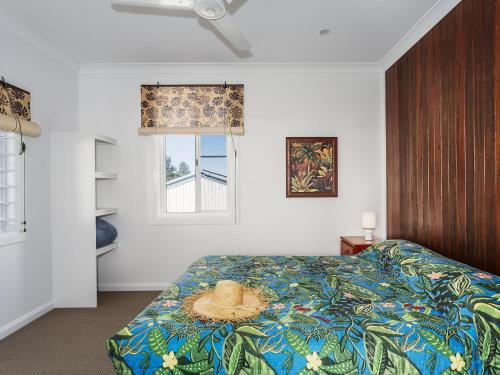 a bedroom with a bed with a hat on it at Aqua Vista - Beach front location in Brooms Head