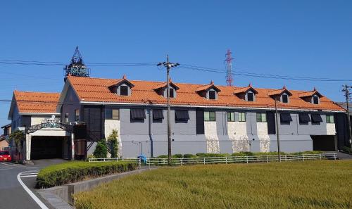 um grande edifício branco com um telhado laranja em hotel due em Ogaki