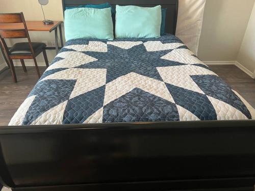 a bed with a black and white quilt on it at Cozy 2 bedrooms by AT&T Stadium in Arlington