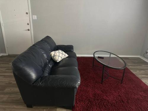 a black leather couch and a glass table in a living room at Cozy 2 bedrooms by AT&T Stadium in Arlington