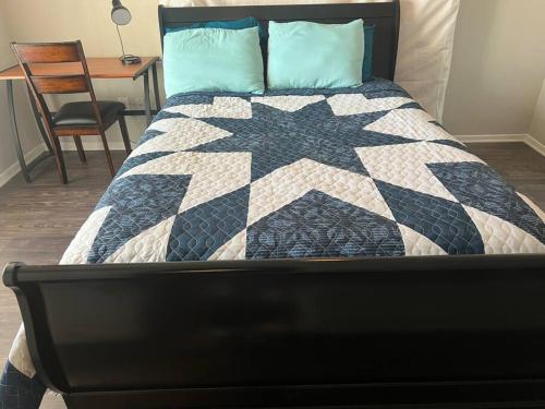 a bedroom with a bed with a black and white quilt at Cozy 2 bedrooms by AT&T Stadium in Arlington