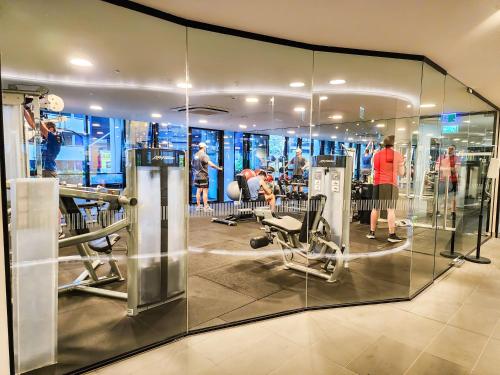 a gym with glass walls and people in it at Modern 2-bedrooms apartment with parking in Melbourne