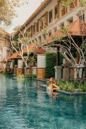a woman in a swimming pool at a hotel at JW Marriott Phuket Resort and Spa in Mai Khao Beach