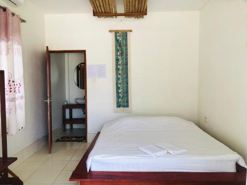 a bedroom with a bed with two white towels on it at Jungle Paradise VangVieng - Bungalows in Vang Vieng