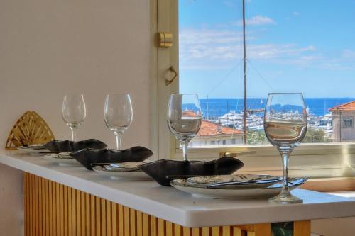 - une table avec des verres à vin et une vue sur l'océan dans l'établissement IMMOGROOM - 5 min from the Croisette beaches - Terrace - Ac - Sea view, à Cannes