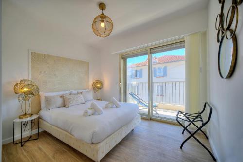 une chambre avec un lit blanc avec une grande fenêtre dans l'établissement IMMOGROOM - 5 min from the Croisette beaches - Terrace - Ac - Sea view, à Cannes