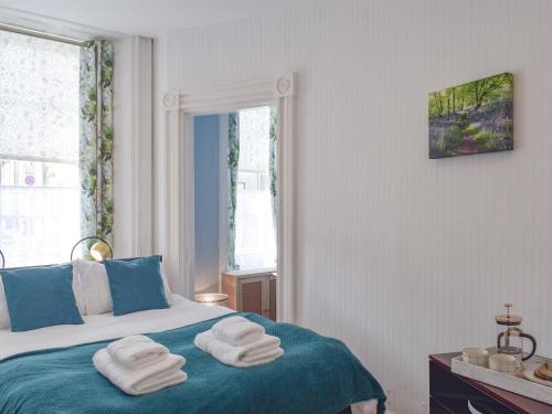 een slaapkamer met een bed met handdoeken erop bij The Secret Garden in Ayr