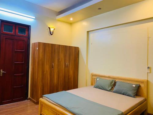 a bedroom with a bed and a wooden cabinet at Su Homestay in Cao Bằng