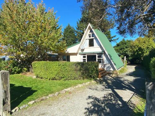 a small white house with a green roof at 47 Woodbank Road in Hanmer Springs