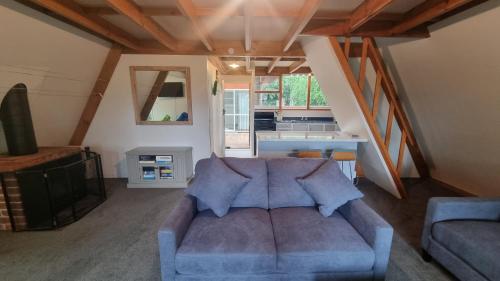 a living room with a blue couch and a kitchen at 47 Woodbank Road in Hanmer Springs