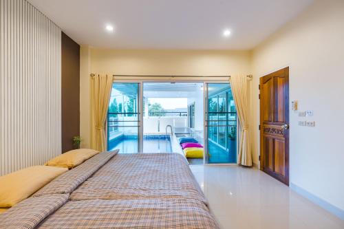 een slaapkamer met een groot bed en een balkon bij Fira villa Huahin in Hua Hin