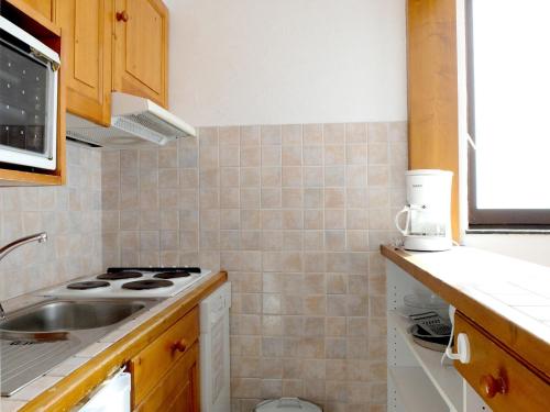 une cuisine avec un évier et une cuisinière dans l'établissement Appartement lumineux 2P pour 6 pers - Proche pistes, balcon, animaux acceptés - FR-1-502-509, à Tignes