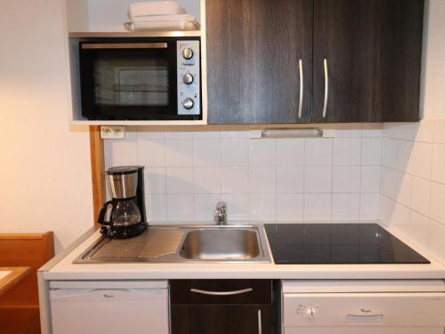 une cuisine avec un évier et un micro-ondes dans l'établissement Appartement skis aux pieds avec balcon, cabine, animal accepté, Tignes Val Claret - FR-1-502-511, à Tignes