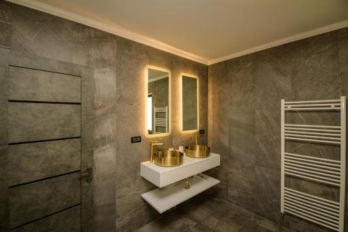 y baño con lavabo y espejo. en Casa Lucan Brașov en Brasov