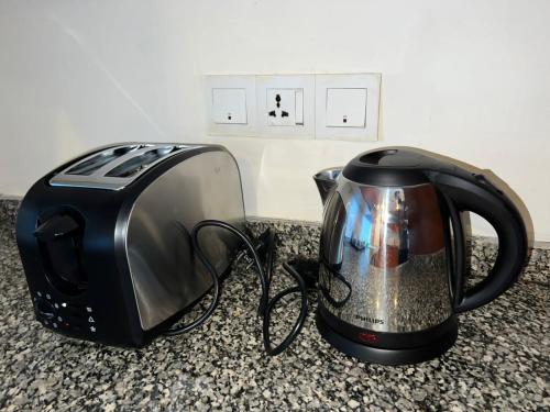 a toaster and a toaster on a counter at Centaurus Two Bedroom Apartment in Islamabad