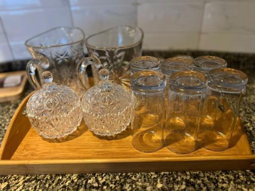 a wooden tray with glass cups and glasses on a counter at Centaurus Two Bedroom Apartment in Islamabad