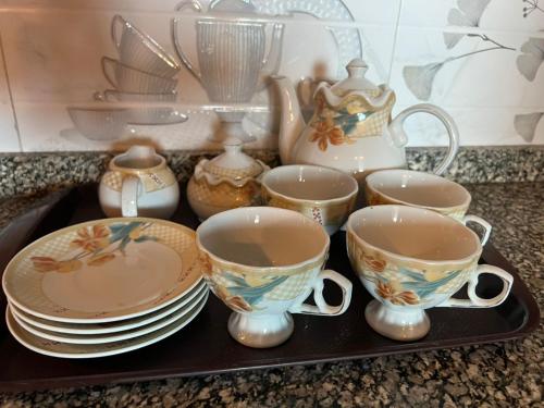 a tray with cups and plates and a tea set at Centaurus Two Bedroom Apartment in Islamabad