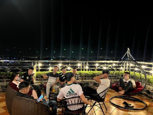 a group of people sitting on a balcony at night at Khách sạn INCO 515.9 in Phủ Lý
