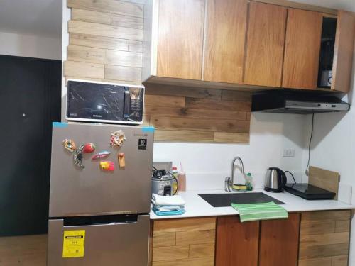eine Küche mit einem Kühlschrank mit Magneten darauf in der Unterkunft Kate's Studio Unit in Davao City