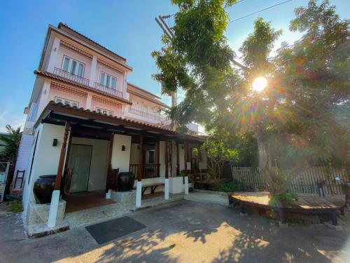 a house with a bench in front of it at Thanicha Resort Amphawa in Amphawa
