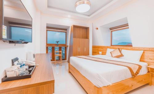 1 dormitorio con 1 cama y escritorio con TV en Hoàng Yến Villa Dalat en Da Lat