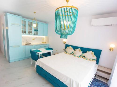 a blue and white bedroom with a bed and a chandelier at Pearl in Ravda
