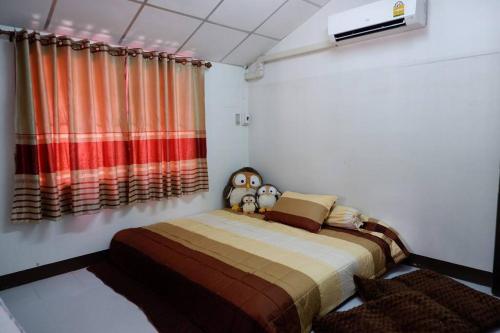 a bedroom with a bed and a window with curtains at บ้านใจกลางเมืองศรีสะเกษ 3นอน2น้ำ in Si Sa Ket