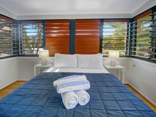 ein Schlafzimmer mit einem Bett mit Handtüchern darauf in der Unterkunft Beachside Palms Unit 2 in Nelly Bay