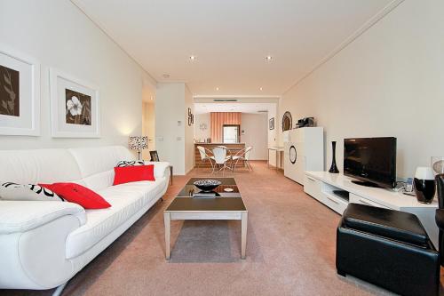 a living room with a white couch and a table at Glebe Park 145 Canberra City ACT in Canberra
