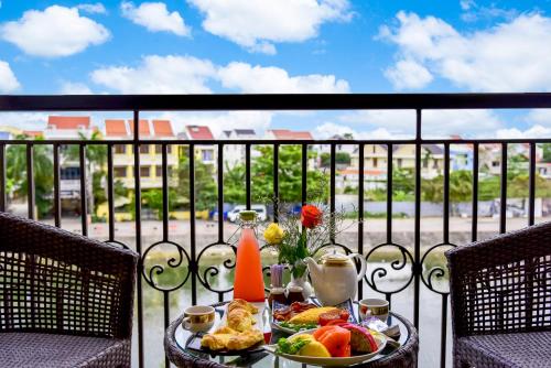a tray of food on a table on a balcony at Laluna Hoi An Riverside Hotel & Spa in Hoi An
