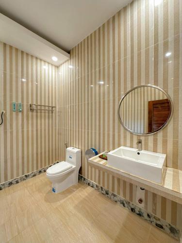 a bathroom with a toilet and a sink and a mirror at Summer Resort in Kep