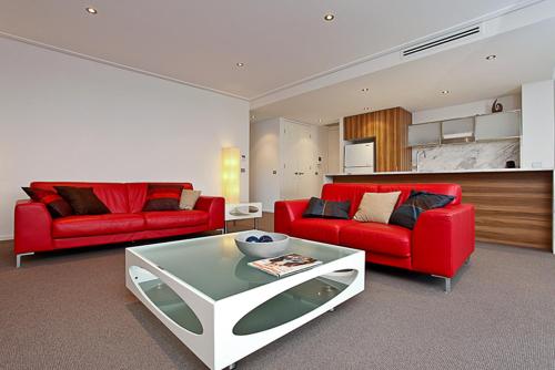 a living room with two red couches and a table at Glebe Park 145 Canberra City ACT in Canberra