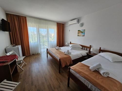 a hotel room with two beds and a television at Vila Rusidava in Eforie Nord