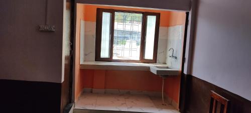 uma casa de banho com um lavatório e uma janela em Gomukh Home Stay em Uttarkāshi