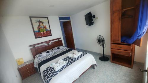 a bedroom with a bed with towels on it at Hotel spa la buena vida in Fusagasuga