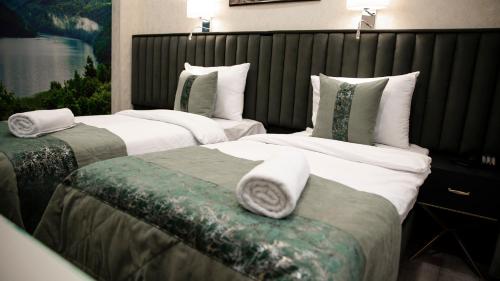 two beds in a hotel room with towels on them at Essam Deluxe Hotel in Baku