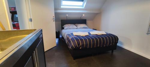 1 dormitorio con 1 cama con 2 toallas en Penthouse 40 m2, en Zemst