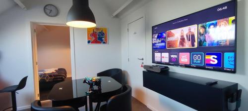 a room with a tv and some chairs and a camera at Penthouse 40 m2 in Zemst