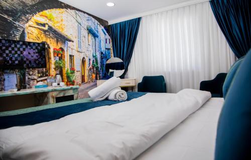 um quarto de hotel com uma cama e um quadro na parede em Essam Deluxe Hotel em Baku