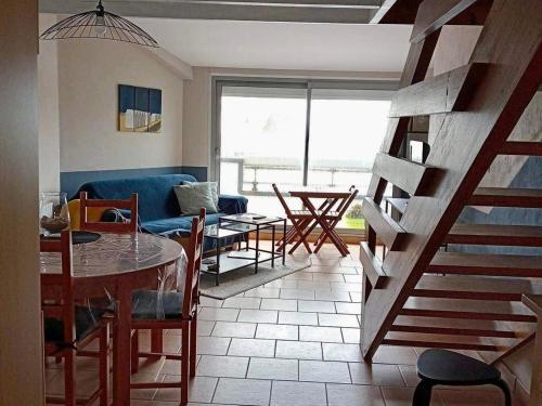 un salon avec un canapé bleu, une table et des chaises dans l'établissement Duplex avec balcon à 2 min de la plage - FR-1-482-103, à Fort-Mahon-Plage