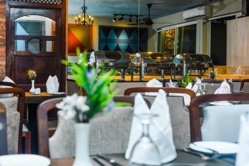 a restaurant with tables and chairs with flowers on them at Tropic Inn - Mount Lavinia in Watumulla