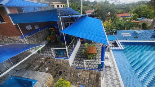 an overhead view of a swimming pool with blue roofs at Hotel spa la buena vida in Fusagasuga