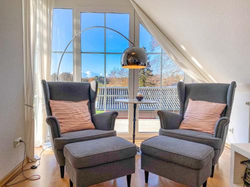 sala de estar con 2 sillas y ventana grande en Bi de Wisch, OG en Prerow