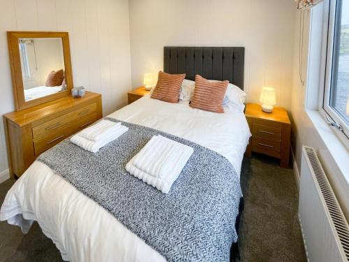a bedroom with a large bed and a mirror at Kilda View in Berneray