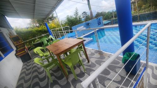 a balcony with a table and chairs next to a swimming pool at Hotel spa la buena vida in Fusagasuga